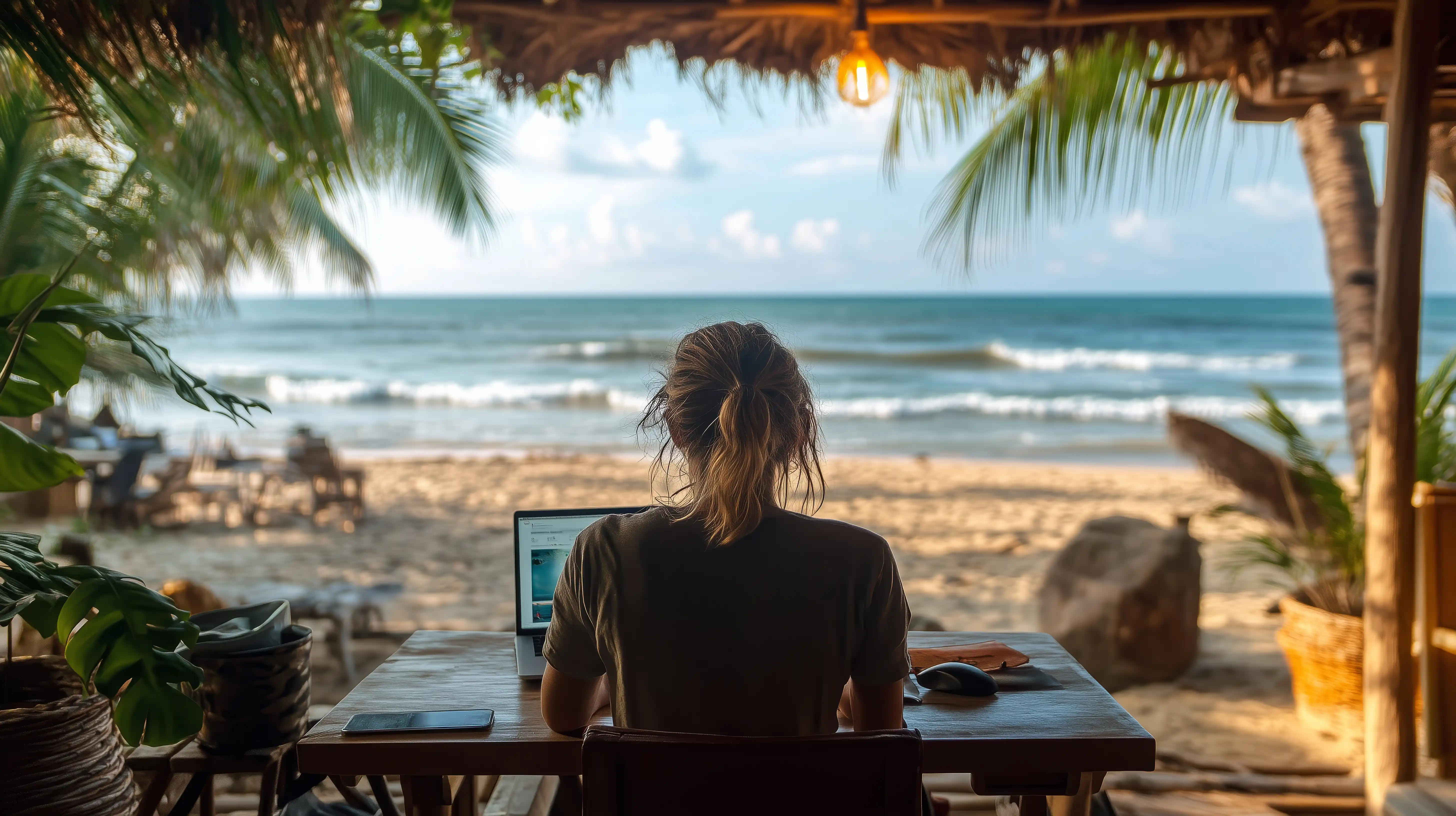 Mujer con su computadora con vista a la playa